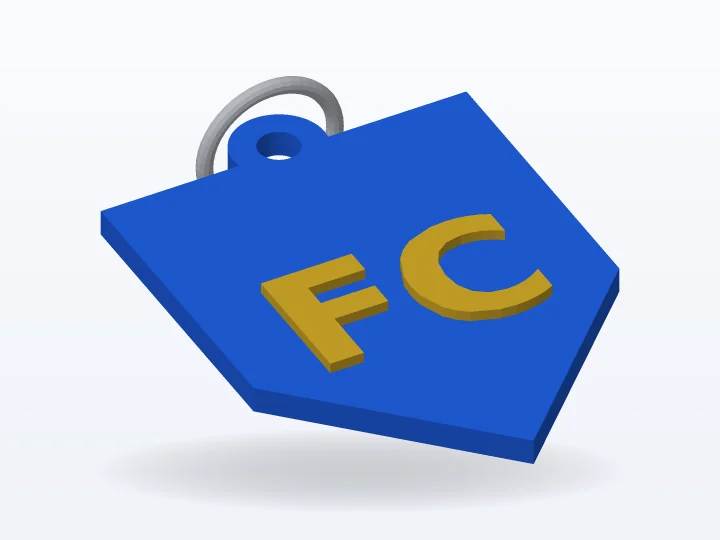 Llavero 3D con forma de escudo azul y letras FC doradas